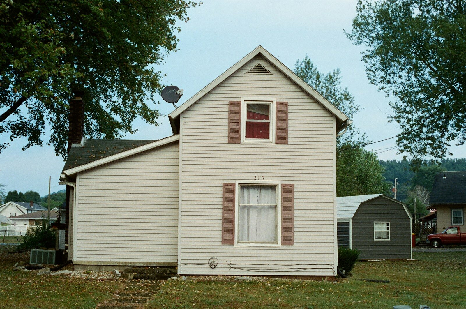 white wooden house near green trees during daytime